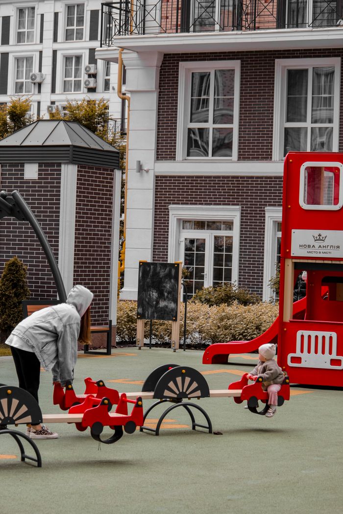 my-path Woman and child enjoying a city playground in Kyiv, Ukraine on a seesaw.