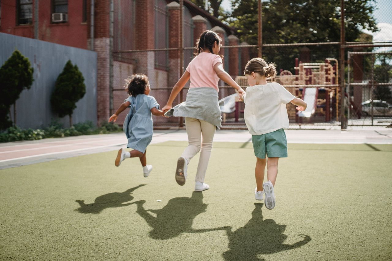 services-img Three kids running joyfully on a sunny playground, embodying happiness and childhood fun.